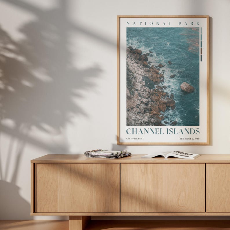 May include: A framed poster depicting the Channel Islands National Park. The image shows a coastal scene with turquoise water and rocky cliffs. The poster includes the text "NATIONAL PARK" at the top and "CHANNEL ISLANDS" at the bottom, with additional text below.