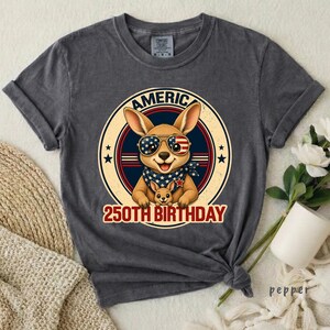 Cute patriotic kangaroo wearing American flag sunglasses shirt, America 250 shirt, funny animal tee, patriotic shirt, retro USA shirt, 4th of July shirt, vintage Americana animal graphic tee, USA 250 anniversary apparel, independence day shirt, animal graphic tee, summer patriotic outfit, funny patriotic animal shirt, freedom celebration shirt, fourth of july tee, cute kangaroo lover gift.