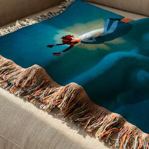 a colorful throw blanket with a vibrant blue and red design, resting on a beige couch.