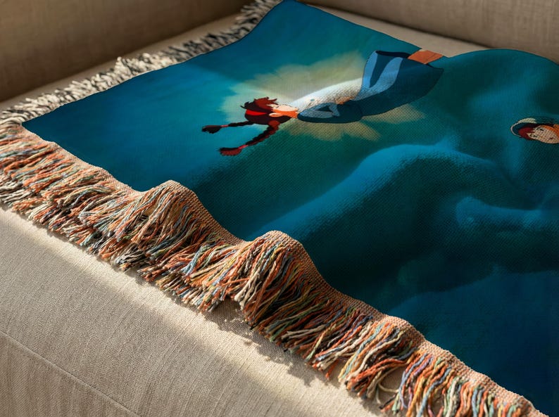 a colorful throw blanket with a vibrant blue and red design, resting on a beige couch.