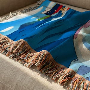 a colorful, patterned blanket with a blue and white design, resting on a beige couch.