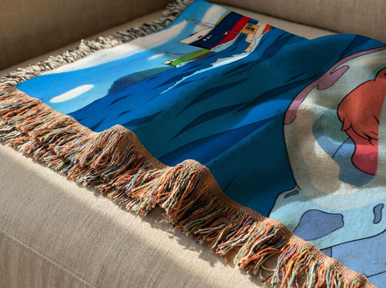 a colorful, patterned blanket with a blue and white design, resting on a beige couch.