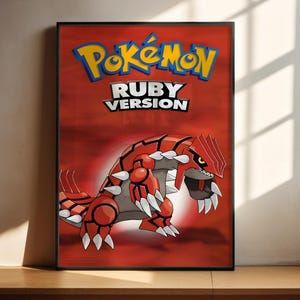 May include: Framed poster with the Pokémon Ruby Version logo and a red and white illustrated creature. The poster has a red background with the Pokémon logo in yellow and blue.