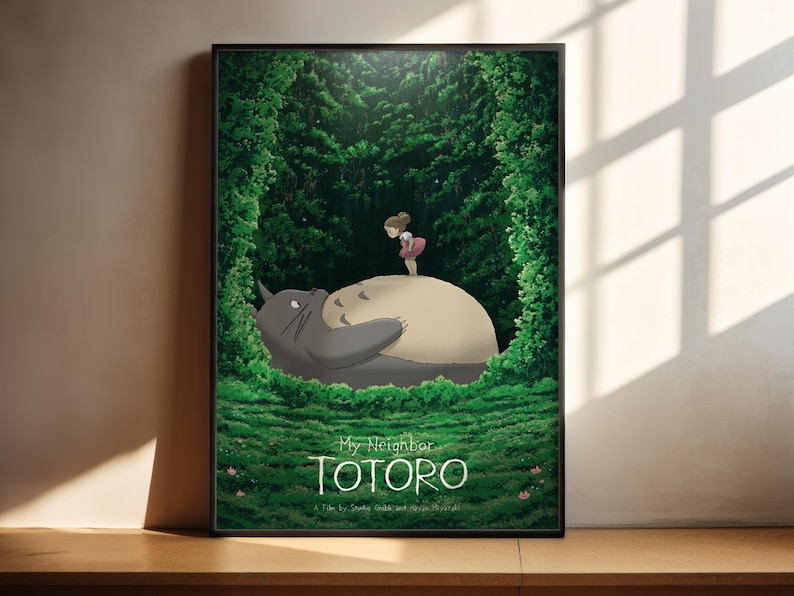 The image is a poster featuring a scene from the animated film "My Neighbor Totoro", depicting a young girl standing on a large, gray cat-like creature in a lush, green forest.