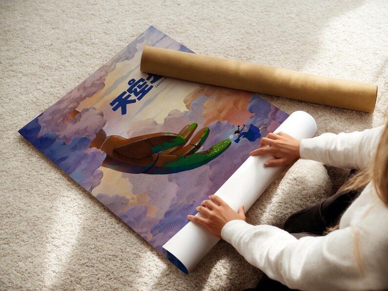 A person is rolling up a poster with a colorful illustration of a bird and clouds on it, which appears to be a poster or artwork.