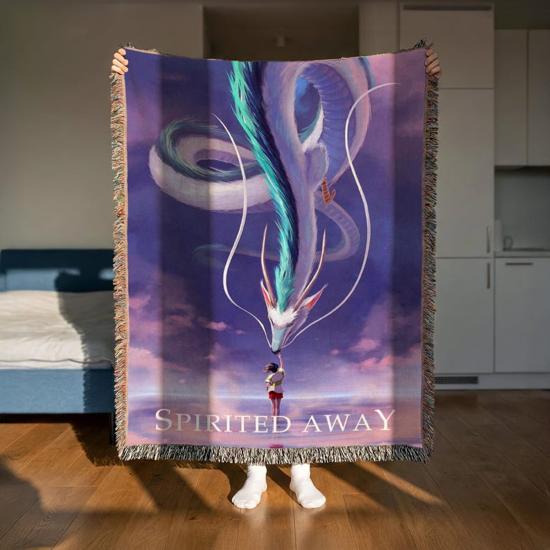 A person is holding up a large, colorful blanket with a dragon design on it.