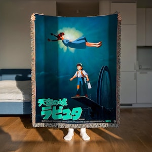 A person is holding up a large poster featuring an animated character, likely from a children's movie, in a room with a bed and a kitchen visible in the background.