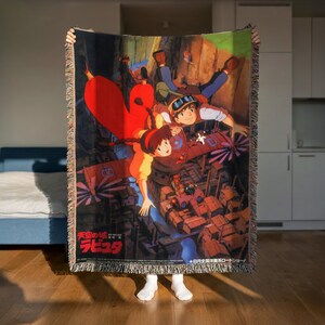 A person is holding up a colorful, cartoon-style poster featuring two characters in an animated scene.