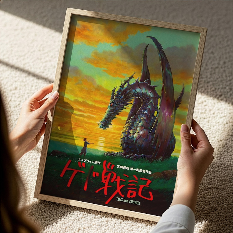 A person is holding a framed poster featuring a large, colorful dragon against a sunset background.