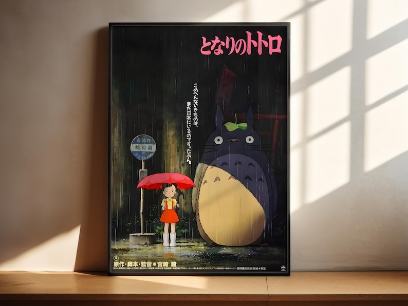 The image is a poster featuring an illustration of a young girl holding an umbrella and standing next to a large, cartoonish cat. The background of the poster is dark, and there is text in Japanese at the top.