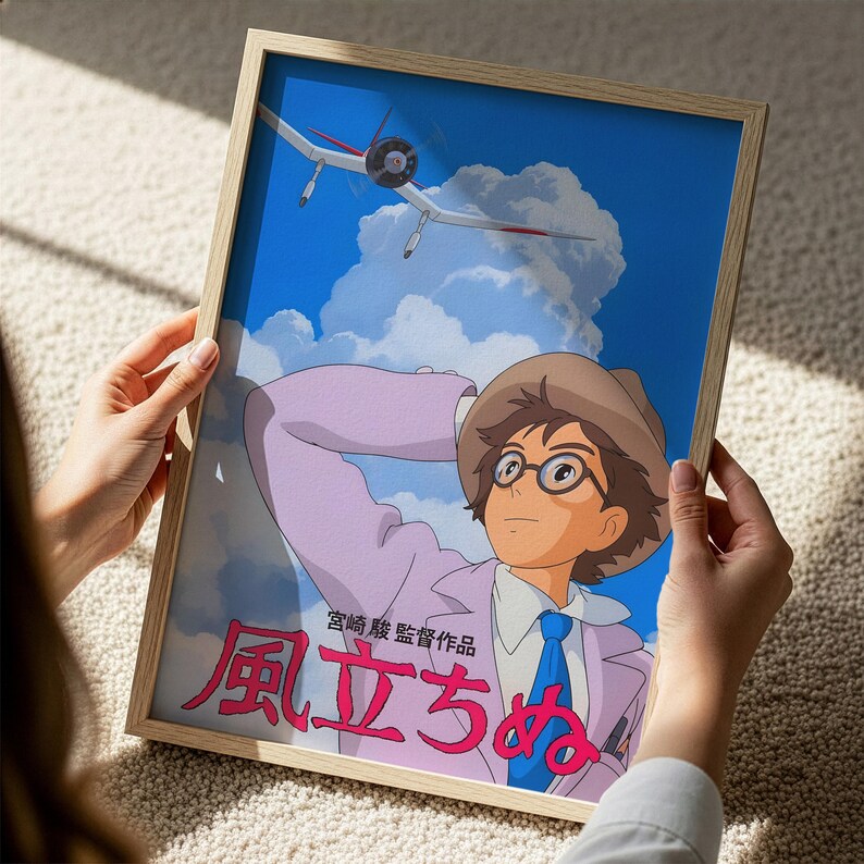 A person is holding a framed poster featuring an animated character with glasses and a hat, who appears to be an airplane pilot. The poster also includes Japanese text, which is not described in detail.