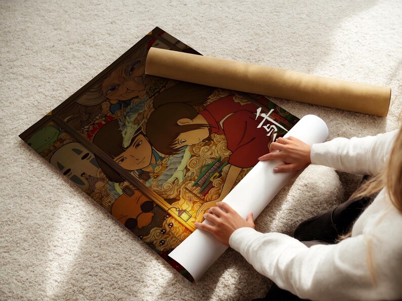 A person is holding a roll of paper and unfolding a poster featuring colorful artwork.