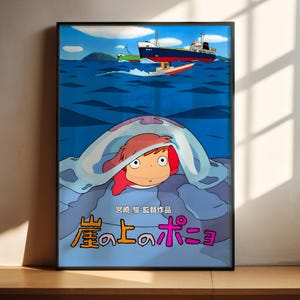 The image is a poster featuring an illustration of Ponyo, a character from the animated film "Ponyo and the Sea of Fog". Ponyo is shown peeking out from under a blanket, with a boat visible in the background. The poster includes Japanese text that translates to "Ponyo is hiding under the blanket".
