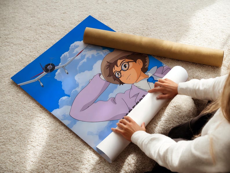 A person is holding a rolled-up poster featuring an illustration of a young boy with glasses and a hat, looking up at an airplane in the sky.