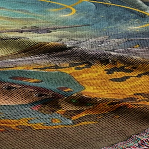 The image is a close-up of a colorful, textured fabric with a detailed, artistic design featuring a character wearing a helmet and surrounded by a fiery, fantastical landscape.