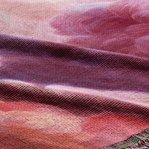 The image is a close-up of a fabric with a floral pattern, featuring a mix of pink, purple, and orange colors.