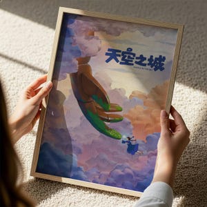 A person is holding a framed artwork depicting a surreal scene with a large, green creature floating in the sky and a smaller, human-like figure below.