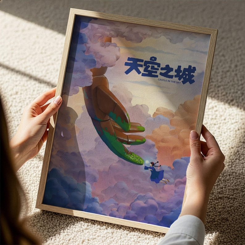A person is holding a framed artwork depicting a surreal scene with a large, green creature floating in the sky and a smaller, human-like figure below.