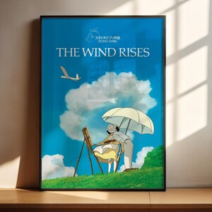 The image is a poster for the animated film "The Wind Rises". It features an illustration of a person holding an umbrella and a bird flying in the sky, set against a backdrop of a blue sky with clouds.