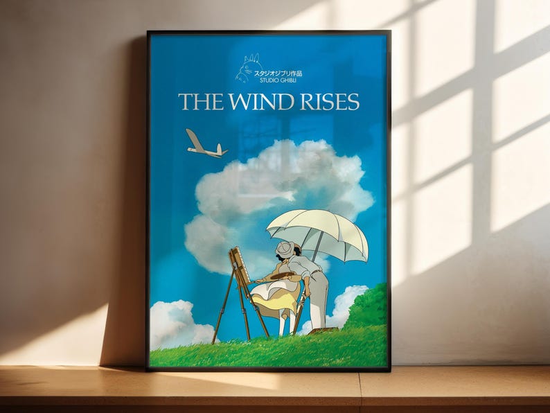 The image is a poster for the animated film "The Wind Rises". It features an illustration of a person holding an umbrella and a bird flying in the sky, set against a backdrop of a blue sky with clouds.