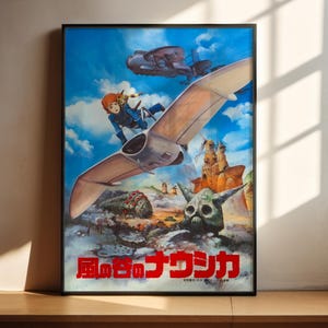 The image is a poster featuring a colorful illustration of a character riding a flying machine, surrounded by various fantastical elements such as a skull, a dragon, and other mythical creatures. The poster is displayed on a wooden surface, with sunlight casting shadows on the wall behind it.