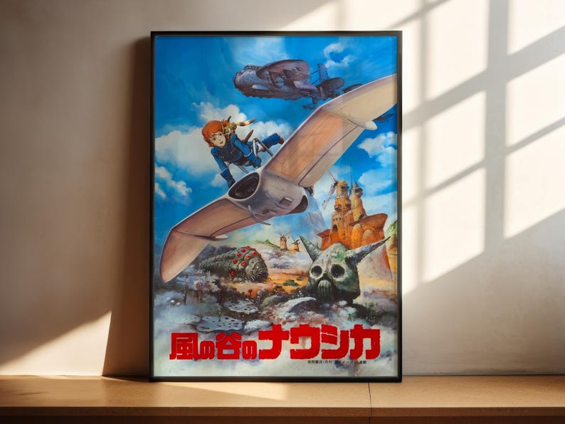 The image is a poster featuring a colorful illustration of a character riding a flying machine, surrounded by various fantastical elements such as a skull, a dragon, and other mythical creatures. The poster is displayed on a wooden surface, with sunlight casting shadows on the wall behind it.