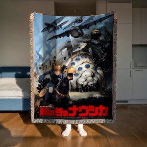 A person is holding up a large poster or painting featuring a character on horseback, with a large airplane in the background. The poster has Japanese text on it, suggesting it may be related to Japanese culture or art.