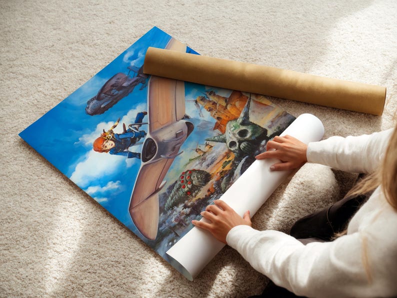 A person is sitting on the floor, holding a roll of paper and unfolding a large poster featuring an illustration of a character and a spaceship.