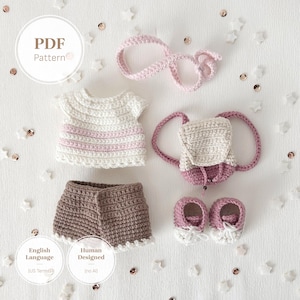 May include: A crochet PDF pattern set featuring a white and light pink striped top, brown shorts, a pink headband, a cream and pink backpack, and a pair of pink and white shoes. The image includes text stating PDF Pattern, English Language (US Terms), and Human Designed.