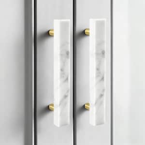May include: Two cabinet pulls with a rectangular shape. The pulls are made of white marble with grey veining and are attached to the cabinet with gold-coloured hardware. The cabinet doors are a light grey colour.