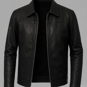 Puede incluir: Chaqueta de cuero negra con cuello camisero y cierre de cremallera completo. La chaqueta presenta un diseño clásico con un corte entallado, costuras visibles y un acabado liso y mate. Las mangas son largas.