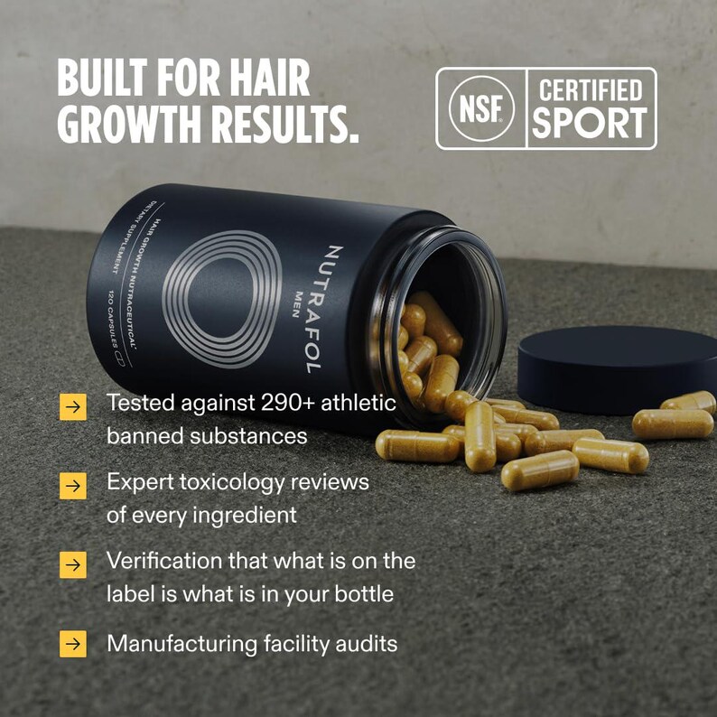 Op de afbeelding: Een zwarte fles Nutrafol Men haargroeisupplement met capsules die eruit vallen. De fles is open, met het deksel ernaast. Tekst op de fles luidt "BUILT FOR HAIR GROWTH RESULTS." en "120 Capsules."