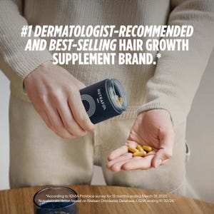 Op de afbeelding: Een donkerblauwe cilindrische fles met Nutrafol Men haargroeisupplementen. De fles wordt door een persoon vastgehouden, met verschillende gele capsules in hun andere hand. Tekst op de fles luidt: "#1 Door dermatologen aanbevolen en bestverkochte haargroeisupplementmerk."