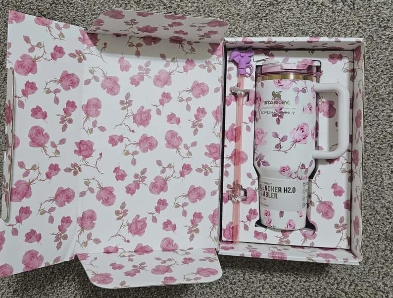 Puede incluir: Una taza de cer&aacute;mica blanca con asa negra y el texto "But First, Coffee" en negrita negra. La taza se encuentra sobre un fondo borroso, sugiriendo un ambiente acogedor.