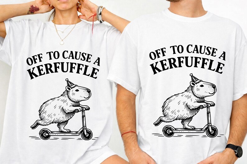 May include: White t-shirts with a black graphic of a capybara riding a scooter and wearing a party hat. The text "OFF TO CAUSE A KERFUFFLE" is printed above the capybara. The shirts are unisex.