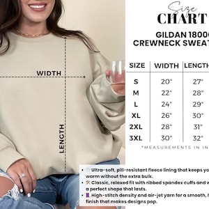 Pu&ograve; includere: Felpa girocollo beige Gildan 18000 con tabella taglie. La tabella mostra le misure in pollici per le taglie S-3XL. La felpa ha una vestibilit&agrave; classica e rilassata con polsini e fascia in vita in spandex a coste.