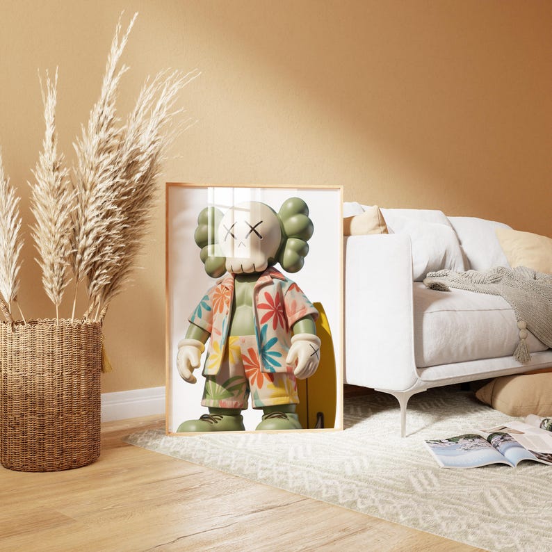 May include: Framed artwork featuring a colorful cartoon figure with a skull-like face and crossbones eyes, wearing a floral shirt and shorts, holding a yellow surfboard. The figure has green hair and is set against a white background.