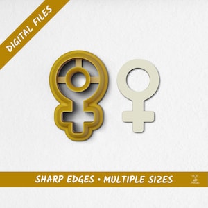 Op de afbeelding: Twee koekjessnijders in de vorm van het vrouwelijke geslachtssymbool. Eén is lichtbeige van kleur en de andere is donkerder geel. De tekst "DIGITAL FILES" en "SHARP EDGES • MULTIPLE SIZES" is ook zichtbaar.