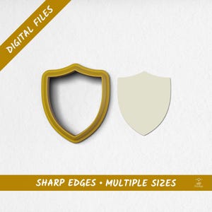 May include: A shield-shaped cookie cutter and a shield-shaped cutout are displayed on a white background. The cookie cutter is gold-colored, and the cutout is off-white. Text at the top reads "DIGITAL FILES" and at the bottom "SHARP EDGES • MULTIPLE SIZES."