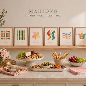 May include: Six framed art prints from the "Mahjong Colorblock Collection" are displayed on a shelf. Each print features a unique abstract design in various colors. The prints are labeled "Dot", "Ram", "Flower", "Dragons", "Winds", and "Joker".