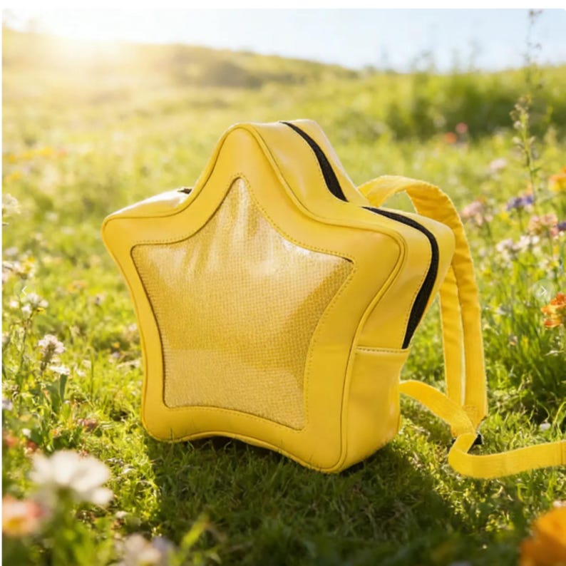 May include: A bright yellow star-shaped backpack featuring a central textured panel and black zipper detailing. The bag includes adjustable yellow shoulder straps and a structured, five-pointed design that maintains its shape while being worn.