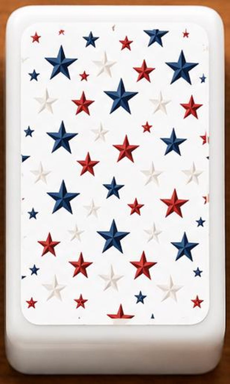 May include: A white rectangular object featuring a pattern of blue, red, and white stars. The stars are of different sizes and are spread across the surface. The object has rounded edges and a smooth, glossy finish.