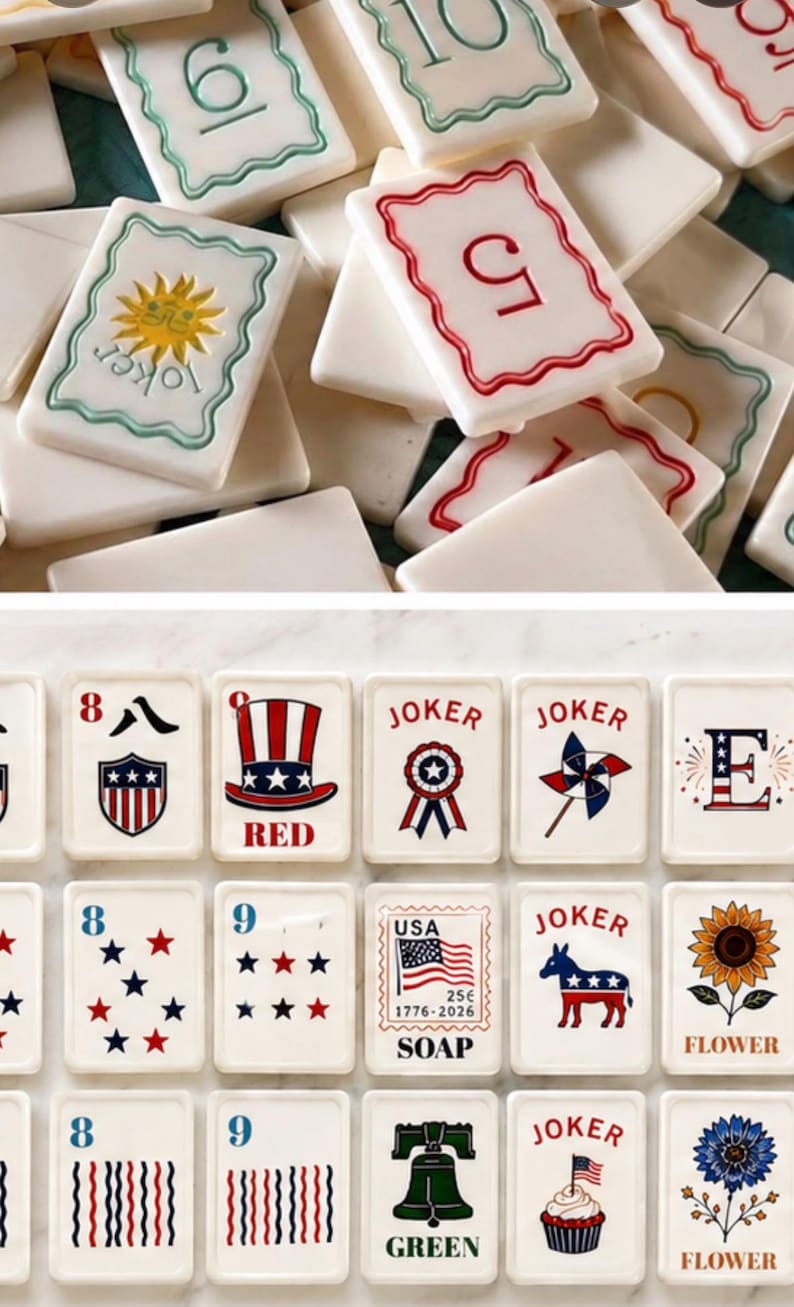 Peut inclure: Un ensemble de savons rectangulaires blancs avec divers motifs. Certains savons affichent des chiffres, tandis que d'autres pr&eacute;sentent des symboles patriotiques, des fleurs et le mot "JOKER". Les savons ont des accents verts, rouges et bleus.