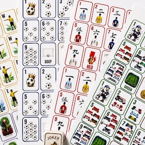Pu&ograve; includere: Una collezione di fogli stampati con vari design di carte da gioco a tema calcistico, incluse carte numerate con palloni, maglie da giocatore, bandiere nazionali e grafiche di stadi, insieme a una piccola scatola con l'etichetta Joker.