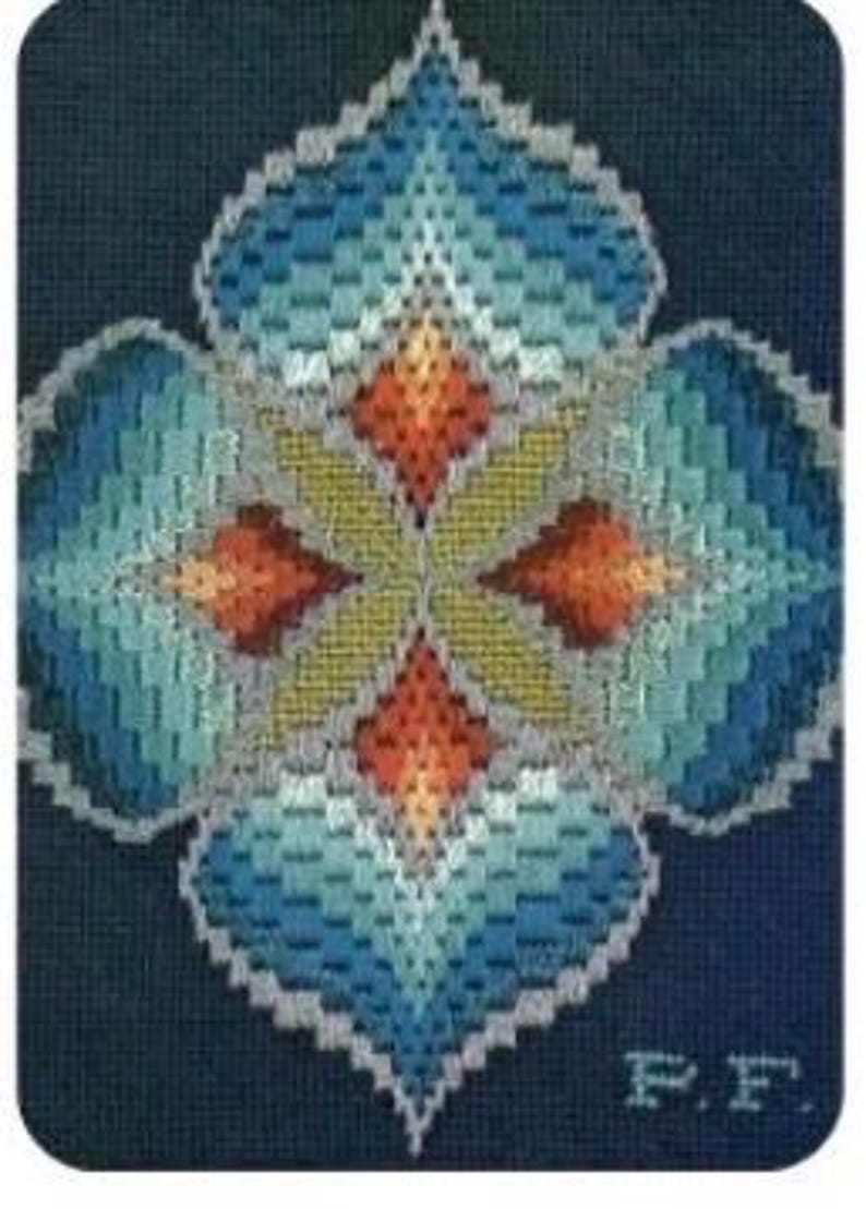 May include: A needlepoint design featuring a symmetrical floral pattern in shades of blue, teal, orange, and yellow. The design is set against a dark blue background. The initials "F.F." are visible in the lower right corner.