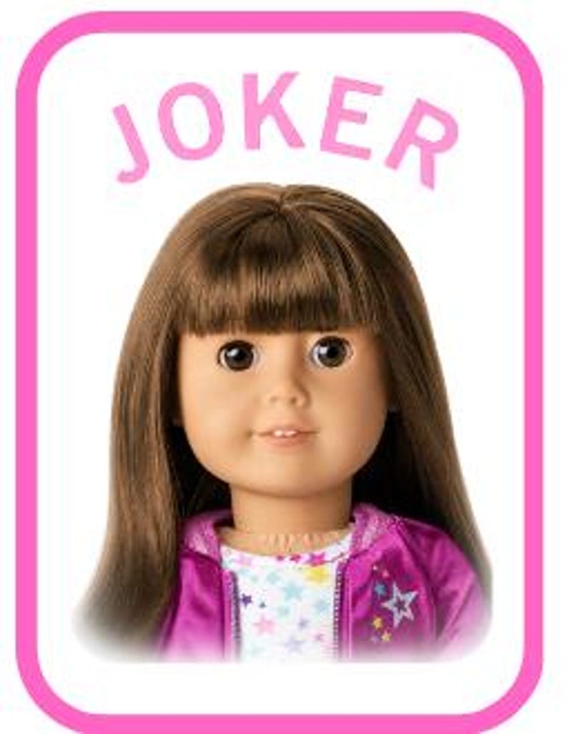 May include: A doll with long brown hair and bangs, wearing a white shirt with a colourful star pattern under a bright magenta zip-up jacket. The word JOKER is printed in pink letters above the doll's head, all framed by a rounded pink border.