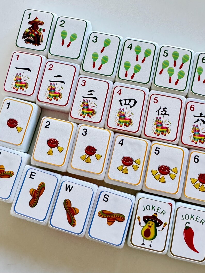 以下が含まれることがあります： カラフルなイラストと数字が描かれた白いゲームタイルのセット。マラカス、ソンブレロ、ピニャータ、サルサやチップスなどの食べ物の画像が特徴です。一部のタイルには中国語の数字と「Joker」の文字があります。