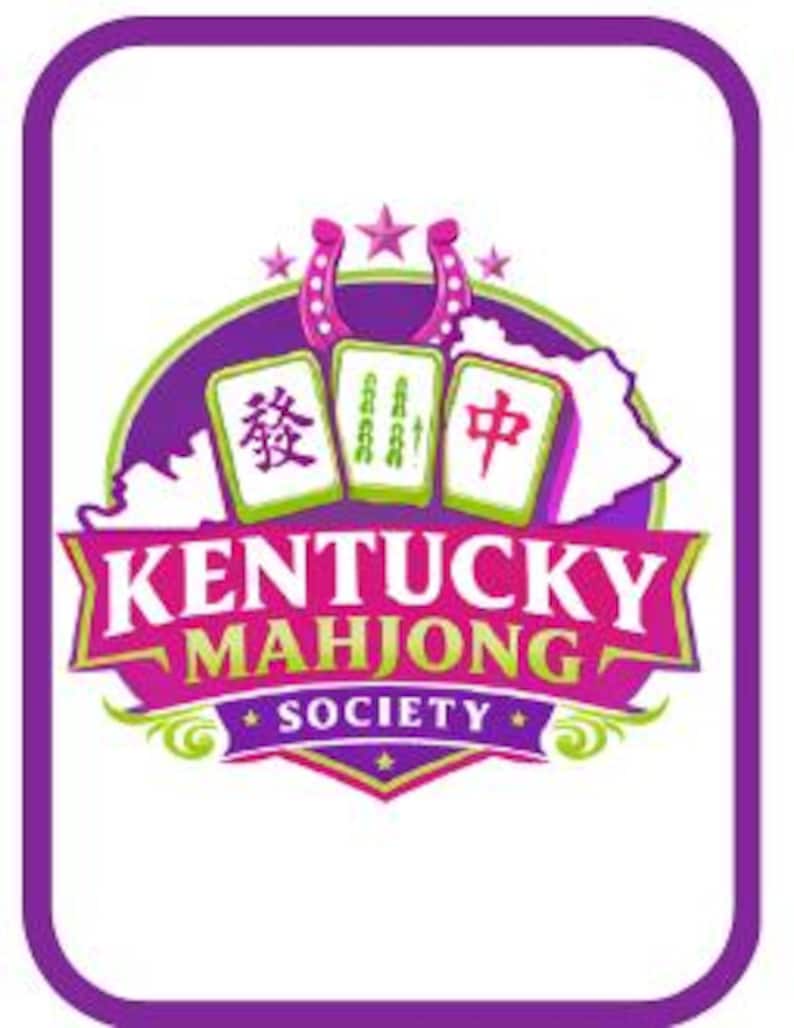 May include: A circular logo with a purple border featuring three mahjong tiles above a pink banner that reads KENTUCKY MAHJONG SOCIETY. The design includes a horseshoe, stars, and a white silhouette of the state of Kentucky on a purple background.