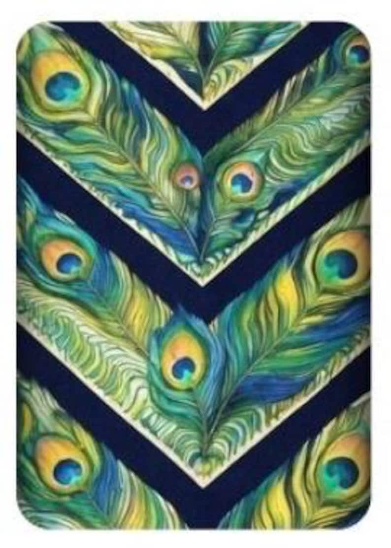 May include: A rectangular decorative item with a repeating pattern of peacock feathers in shades of blue, green, and yellow. The feathers are arranged in a chevron design against a dark blue background.