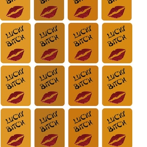 May include: A sheet of twenty-four rectangular stickers with a mustard yellow background. Each sticker features the black text LUCKY BITCH in a distressed font above a dark red graphic of a pair of lips. The stickers are arranged in a grid.